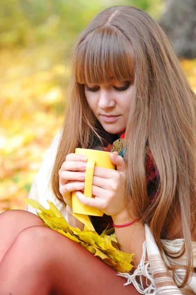 Jonge mooie vrouw die houdt de kop thee in handen op een ba — Stockfoto
