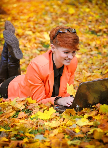 手提电脑在片秋色的公园的可爱女人 — 图库照片