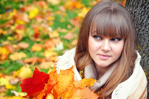 Portrait de belle jeune femme aux feuilles d'automne — Photo