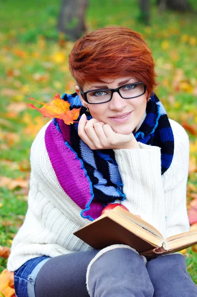 Hermosa chica con libro en el parque de otoño — Foto de Stock