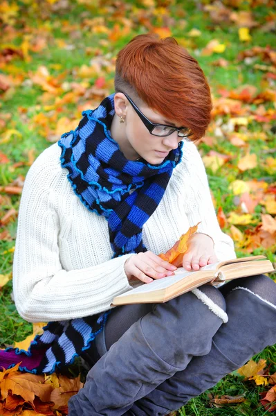 Mooi meisje met boek in de herfst park — Stockfoto