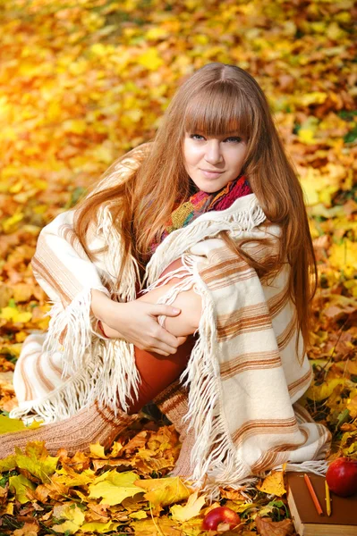 Schöne Mädchen mit Notizbuch auf einem Hintergrund Herbstblätter — Stockfoto