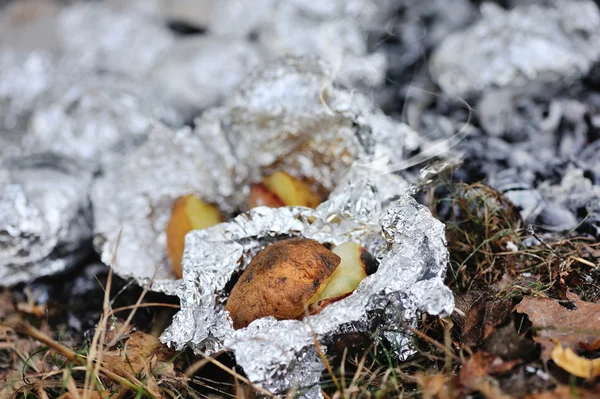 Запеченный картофель, обжаренный на костре из алюминиевой фольги — стоковое фото
