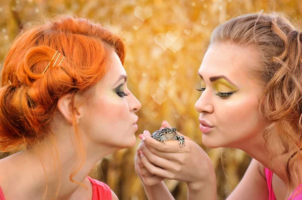 Beautiful young girls holding a cute frog — Stock Photo, Image