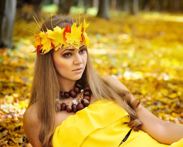 Retrato de una hermosa niña en una corona de hojas de otoño —  Fotos de Stock