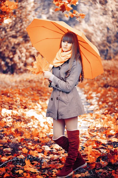 Hermosa joven está en un parque de otoño con un paraguas — Foto de Stock