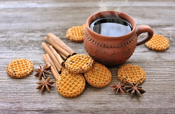 Чашка горячего чая с печеньем на деревенском деревянном фоне — стоковое фото