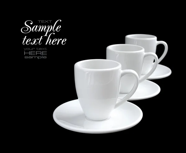 Пустые белые кофейные чашки и тарелки на черном фоне — стоковое фото