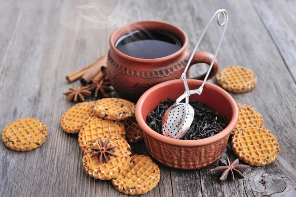 Una tazza di tè caldo con biscotti su uno sfondo di legno rustico — Foto Stock
