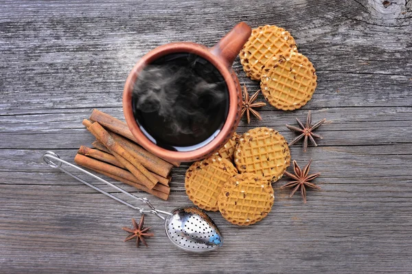 Una tazza di tè caldo con biscotti su uno sfondo di legno rustico — Foto Stock