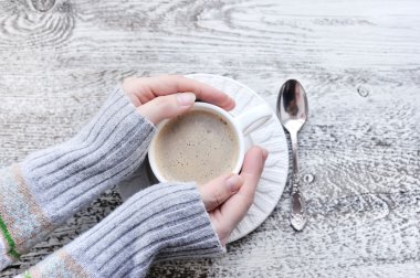 Erkek holding bardak kahve ahşap masa arka plan, üstten görünüm üzerinde eller