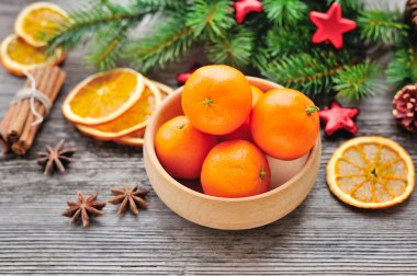 Mandalina ve ahşap bir masa üzerinde Noel ağacı dalları