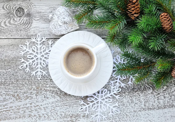 Чашки кофе и елки с рождественскими украшениями на фоне деревянного стола — стоковое фото