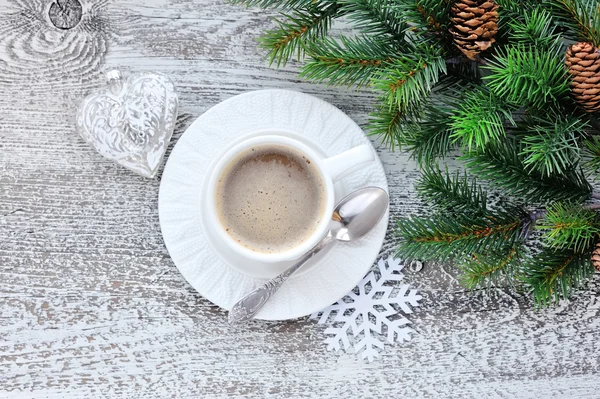 Чашки кави та ялинкових гілок з різдвяними прикрасами на дерев'яному фоні столу — стокове фото