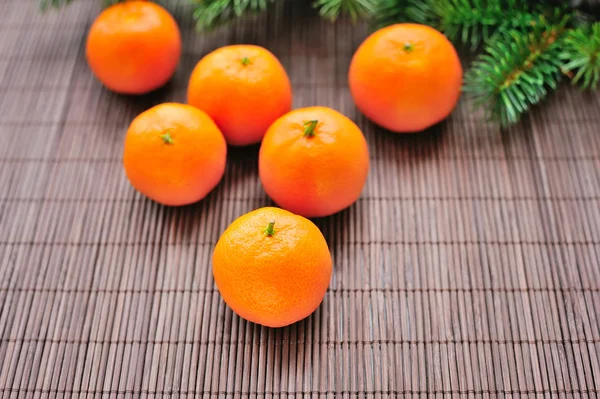 Tangerines and fir branches on table — Stock Photo, Image