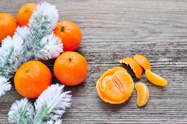 Mandalina ve çam dalları Frost'un üzerinde eski ahşap arka plan ile — Stok fotoğraf