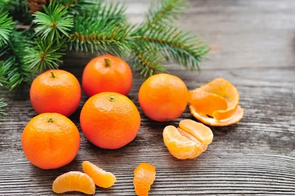 Tangerines and Christmas tree branches on a wooden table — Stock Photo, Image