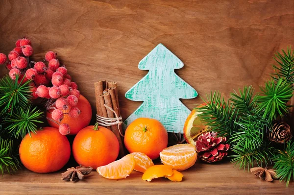 Tangerines et branches de sapin avec décorations de Noël sur fond en bois — Photo