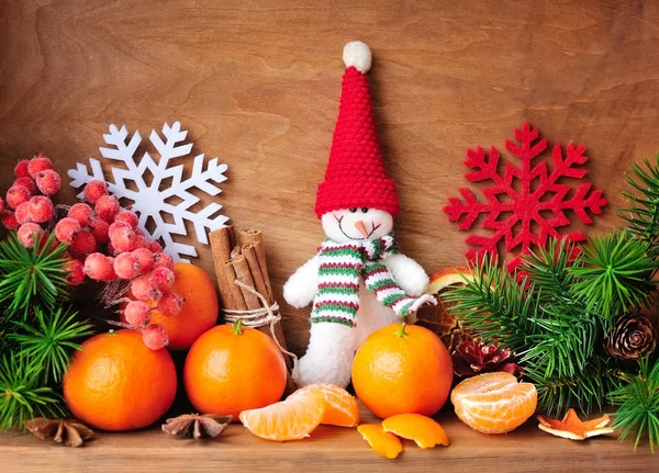 Bonhomme de neige aux mandarines et branches de sapin et décorations de Noël sur fond de bois — Photo