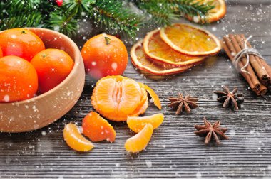 Mandalina ve Noel ağacı dalları üzerinde ahşap bir masa. Doğal Noel dekor