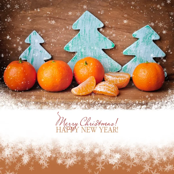 Mandarinen und hölzerne Weihnachtsbäume auf altem Holzgrund — Stockfoto