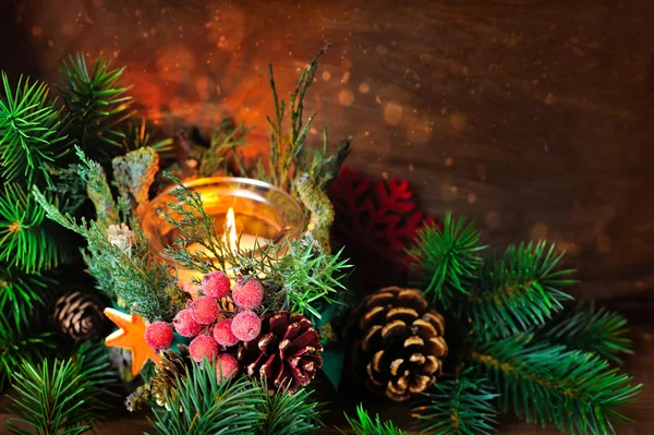 Candlestick and Christmas tree branches on a wooden background — Stok fotoğraf