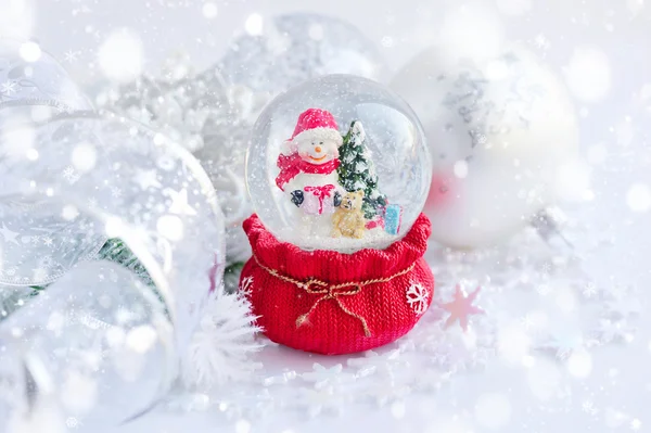 Un globo di neve con pupazzo di neve e decorazioni natalizie — Foto Stock