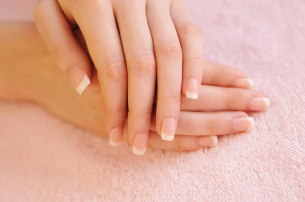 Mãos de mulher com bela manicure francesa — Fotografia de Stock