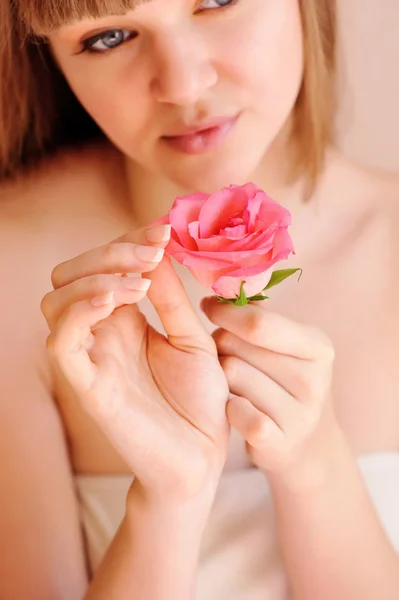 Mooi meisje met roze bloem aanraken van haar gezicht. huidverzorging concept — Stockfoto