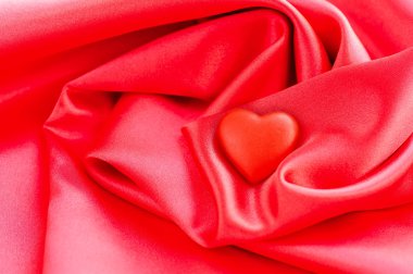 Saten kumaş arka plan üzerinde kırmızı kalp