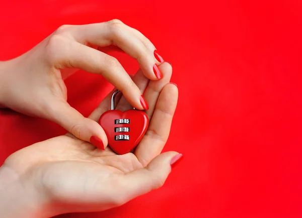 Lakat szív-alakú nők kezében a háttér piros selyem — Stock Fotó