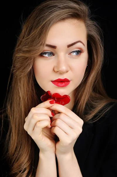 Красивая девушка с двумя красными сердечками конфеты — стоковое фото