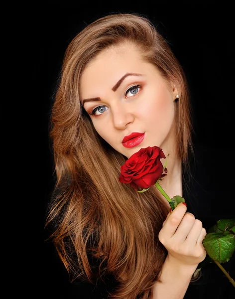 Mooie vrouw met rode roos op zwarte achtergrond — Stockfoto