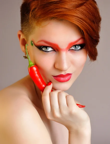 Retrato de mujer hermosa con maquillaje rojo creativo mantiene chiles — Foto de Stock