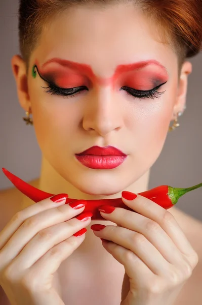 A kreatív piros smink gyönyörű nő portréja tartja chili paprika — Stock Fotó