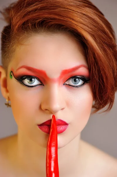 Retrato de mujer hermosa con maquillaje rojo creativo mantiene chiles —  Fotos de Stock