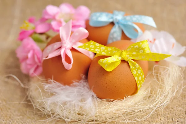 Easter eggs in the nest on a burlap — Stock Photo, Image