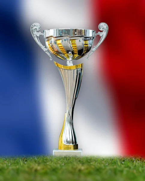 Troféu dourado na grama no fundo da bandeira da frança — Fotografia de Stock