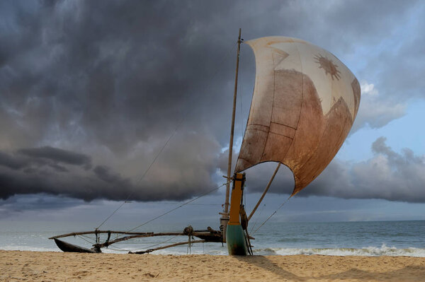 Fishing boats resting on empty beach in Sri Lanka hour to storm  