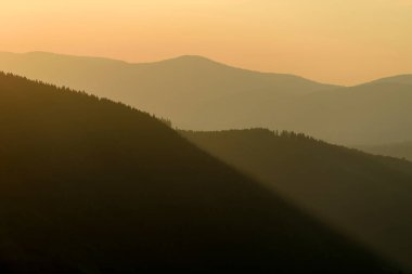 Güneşli ışıklarla dağlarda görkemli günbatımı