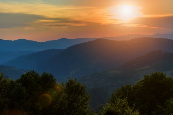 太陽の光が差し込む山の風景の中の雄大な夕日 — ストック写真