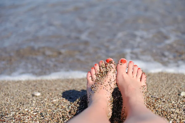 Vrouw voeten close-up van meisje ontspannen op het strand — Stockfoto