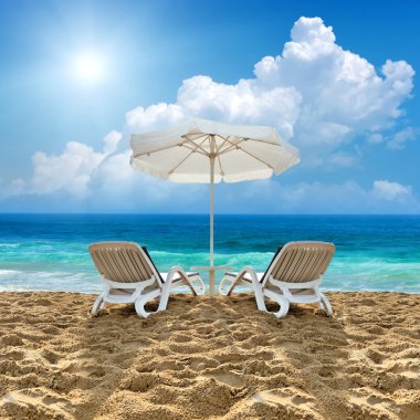 Plajda plaj sandalye ve beyaz şemsiye