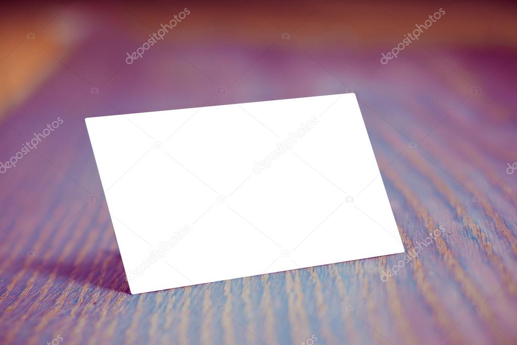 Horizontal business card mockup over red wood background.