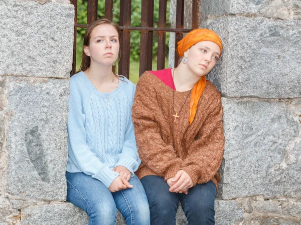 Zwei Mädchen sitzen in einem Steinfenster — Stockfoto