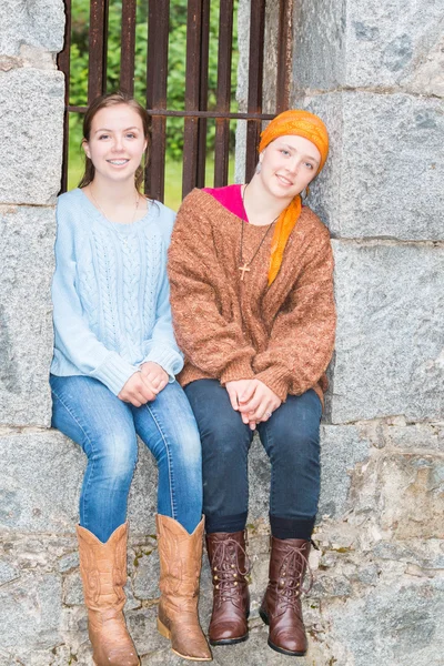 Zwei Mädchen sitzen in einem Steinfenster — Stockfoto