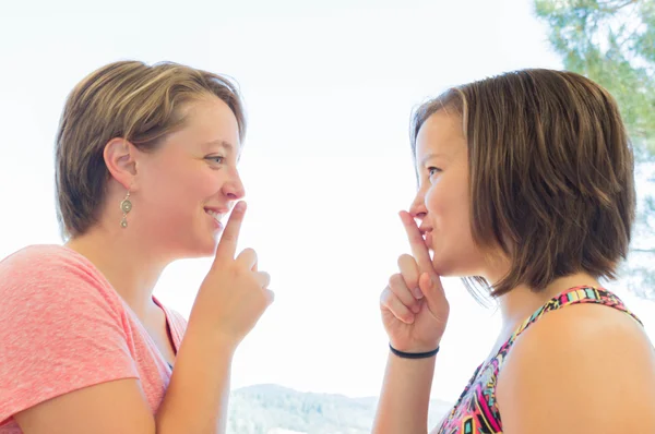 Nahaufnahme zweier süßer Mädchen, die um Schweigen bitten — Stockfoto