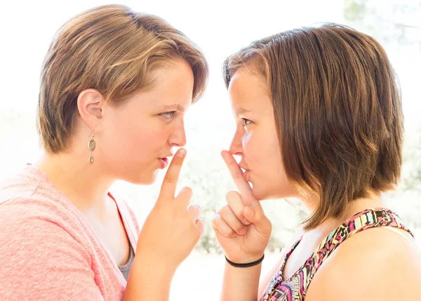 Nahaufnahme zweier süßer Mädchen, die um Schweigen bitten — Stockfoto