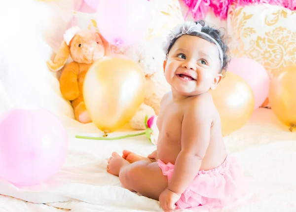 Bebê menina sentada com almofadas e balões — Fotografia de Stock