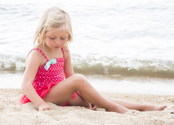 Liten flicka sola på stranden — Stockfoto
